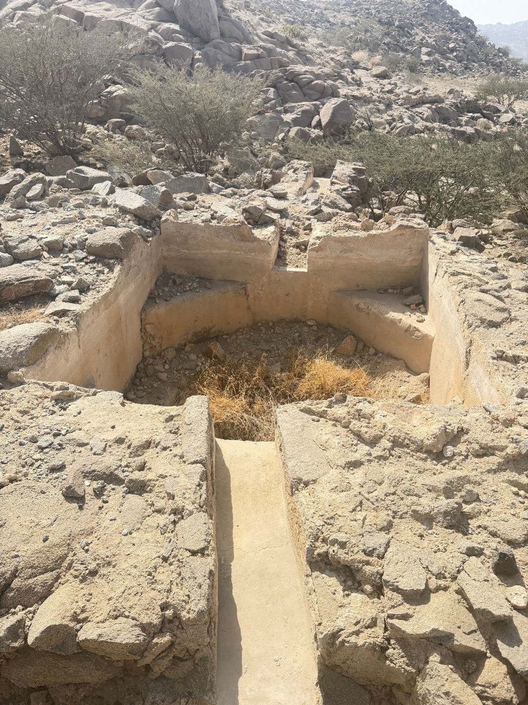 أحد الأحواض المائية في موقع بركة أم الضميران مع قناة توجيه للمياه.